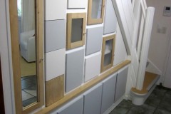 Agencement sous escalier, bois composite et chêne, finition laquée sur mesure et vernis chêne clair.